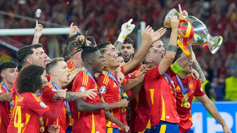 Spain players celebrate with the winner's trophy of the Euro 2024 soccer tournament after the final match between Spain and England in Berlin, Germany, Sunday, July 14, 2024. (AP Photo/Martin Meissner)