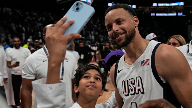 United States' Stephen Curry takes a selfie with a fan after an exhibition basketball match between Serbia and the United States at the USA Basketball Showcase, ahead of the 2024 Paris Olympic basketball tournament, in Abu Dhabi, United Arab Emirates, Wednesday, July 17, 2024. (AP Photo/Altaf Qadri)