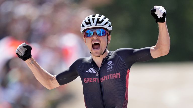 Tom Pidcock celebrates after recovering from a puncture to retain his Olympic mountain bike cross country title