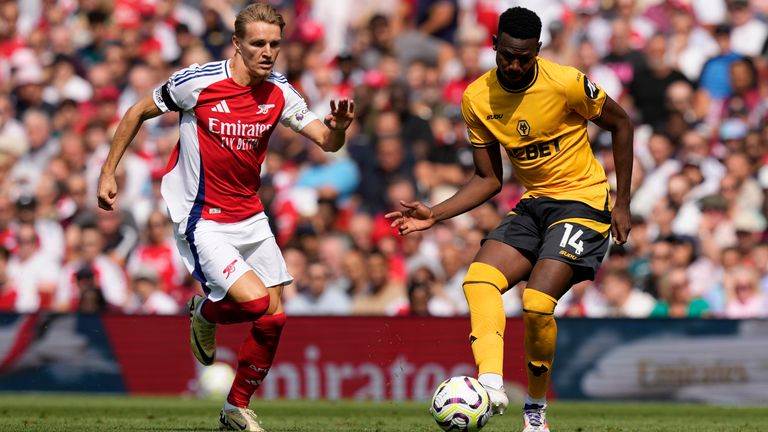 Arsenal's Martin Odegaard, left, challenges for the ball with Wolverhampton Wanderers' Yerson Mosquera during the English Premier League soccer match between Arsenal and Wolverhampton Wanderers at Emirates Stadium in London, England, Saturday, Aug. 17, 2024. (AP Photo/Frank Augstein)