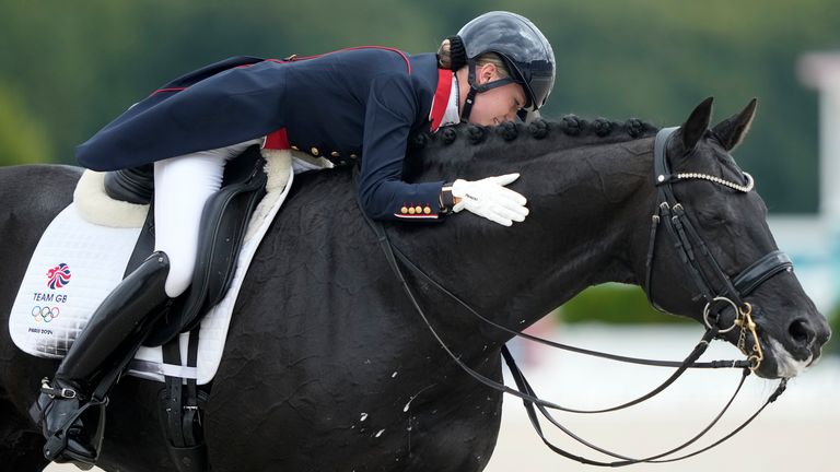 Britain's Charlotte Fry pats Glamourdale during the dressage team Grand Prix final at the 2024 Summer Olympics