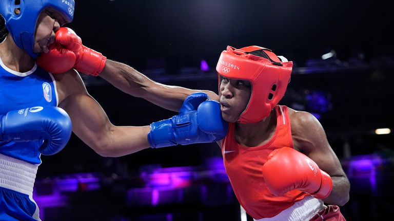 Refugee Olympic Team's Cindy Ngamba hits France's Davina Michel in their women's 75 kg quarterfinal boxing match at the 2024 Summer Olympics, Sunday, Aug. 4, 2024, in Paris, France. (AP Photo/Ariana Cubillos)