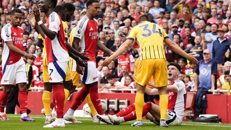 Arsenal's Declan Rice sits on the floor as he argues with Brighton's Joel Veltman (second right) before receiving a red card