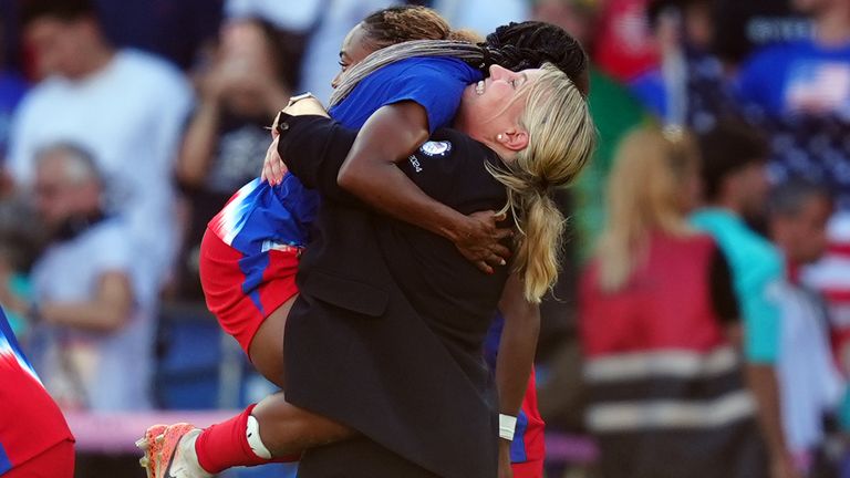 Emma Hayes celebrates with her players after the USA won the Olympic gold medal