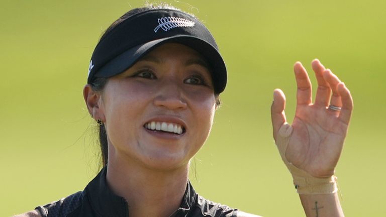 Lydia Ko, of New Zealand, acknowledges the crowd, with tears in her eyes after winning the gold medal as she celebrates while walking on the 18th green after the final round of the women's golf event at the 2024 Summer Olympics, Saturday, Aug. 10, 2024, at Le Golf National, in Saint-Quentin-en-Yvelines, France. (AP Photo/Matt York)