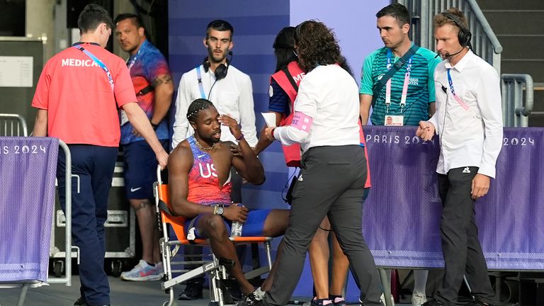 Noah Lyles, of the United States, is helped off the track after the men's 200-meter final at the 2024 Summer Olympics, Thursday, Aug. 8, 2024, in Saint-Denis, France. (AP Photo/Matthias Schrader)