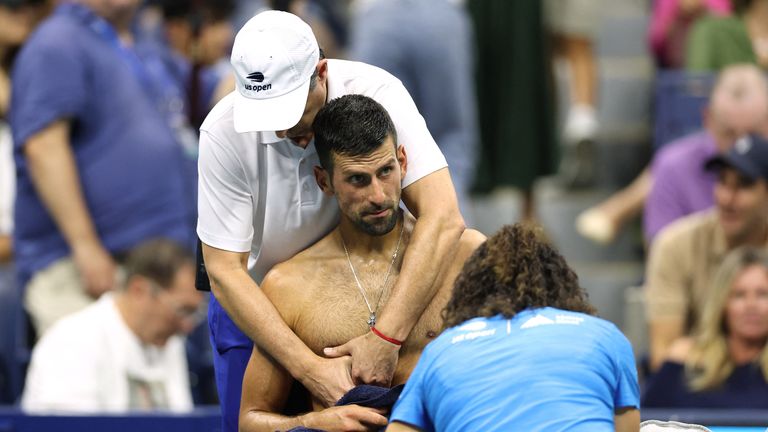 Serbia's Novak Djokovic receives medical attention during his men's singles second round tennis match against Serbia's Laslo Djere on day three of the US Open tennis tournament at the USTA Billie Jean King National Tennis Center in New York City, on August 28, 2024. (Photo by CHARLY TRIBALLEAU / AFP)