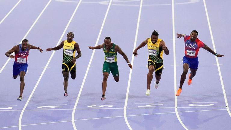 Noah Lyles, of the United States, Oblique Seville, of Jamaica,Akani Simbine, of South Africa, Kishane Thompson, of Jamaica, and Fred Kerley, of the United States, cross the finish line in the men's 100 meters final at the 2024 Summer Olympics, Sunday, Aug. 4, 2024, in Saint-Denis, France. Lyles won, Thompson was second and Kerley third. (AP Photo/Martin Meissner)