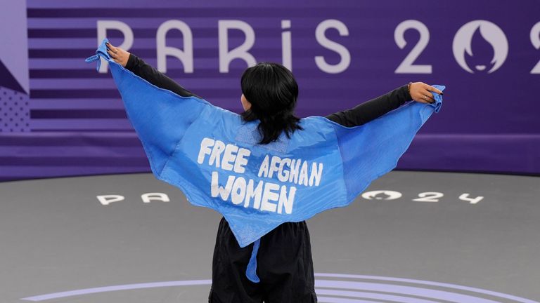 Refugee Team's Manizha Talash, known as Talash, wears a cape which reads "free Afghan women" as she competes during the B-Girls Pre-Qualifier Battle at the breaking competition at La Concorde Urban Park