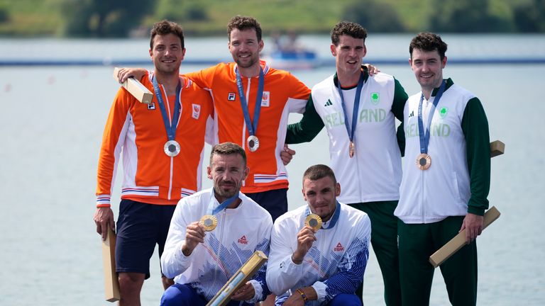 Silver medalists Netherland's Melvin Twellaar and Stef Broenink, back left, gold medalists, Romania's Andrei Sebastian Cornea and Marian Florian Enache, front, and bronze medalists Ireland's Daire Lynch and Philip Doyle pose during a medals ceremony for the men's double sculls final at the 2024 Summer Olympics, Thursday, Aug. 1, 2024, in Vaires-sur-Marne, France. (AP Photo/Lindsey Wasson)