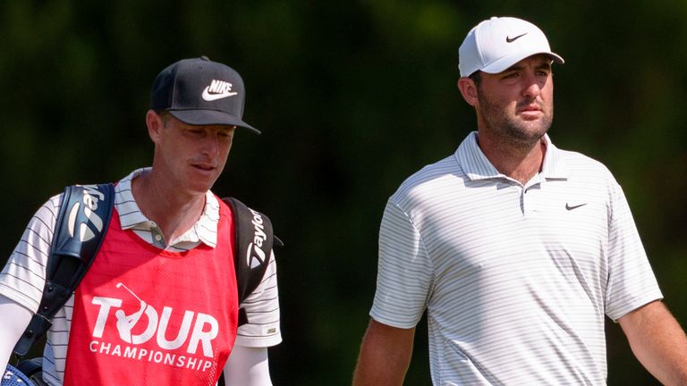 Scottie Scheffler, right, and his caddie walk to his drive on the fairway of the seventh hole during the third round of the Tour Championship golf tournament, Saturday, Aug. 31, 2024, in Atlanta. (AP Photo/Jason Allen)