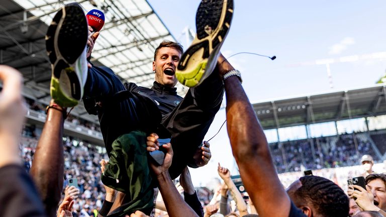 St. Pauli coach Fabian Hurzeler is lifted by fans who invaded the field after their team won 3-1 during a second division, Bundesliga, soccer match between FC St. Pauli and VfL Osnabrueck, at the Millerntor Stadium, in Hamburg, Germany, Sunday, May 12, 2024. St. Pauli has returned to the Bundesliga after a 3-1 win over relegated Osnabr..ck in Germany...s second division. (Axel Heimken/dpa via AP)