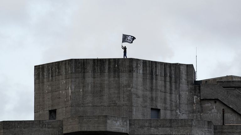 A supporter of St. Pauli waves a team flag from a bunker nearby during the Bundesliga match between FC St. Pauli Hamburg and1899 Hoffenheim at Millerntor Stadium on August 28, 2010 in Hamburg,