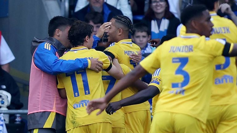 Leeds players mob goalscorer Largie Ramazani after taking the lead at Cardiff