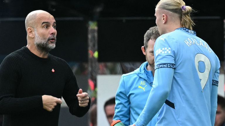 Erling Haaland speaks to Pep Guardiola as he receives treatment for an injury on the touchline