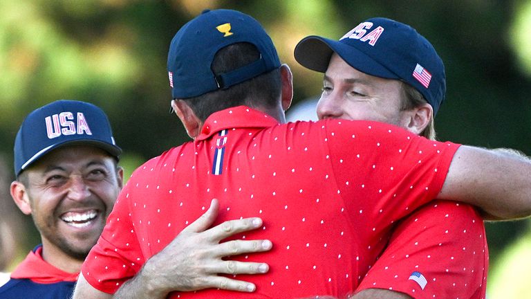 United States team member Keegan Bradley, center, is congratulated by teammates Xander Schauffele, left, and Russell Henley, right, after the U.S. won the Presidents Cup tournament over team International at the Royal Montreal Golf Club in Montreal, Sunday, Sept. 29, 2024. (Graham Hughes/The Canadian Press via AP) 