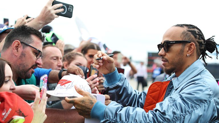 Lewis Hamilton signs autographs