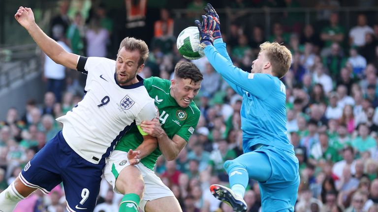 Caoimhin Kelleher beats Harry Kane to clear a dangerous cross