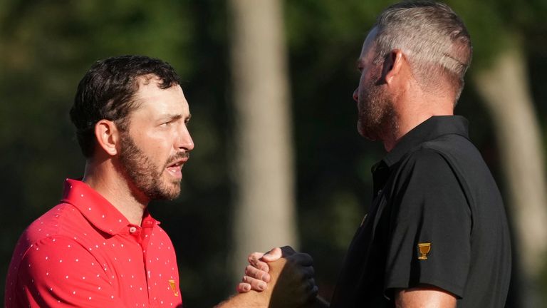 United States team member Patrick Cantlay, left, shakes hands with International team member Taylor Pendrith, right, of Canada, after winning their match on the 17th hole during their fifth-round singles match at the Presidents Cup golf tournament at Royal Montreal Golf Club, Sunday, Sept. 29, 2024, in Montreal. (Christinne Muschi/The Canadian Press via AP)