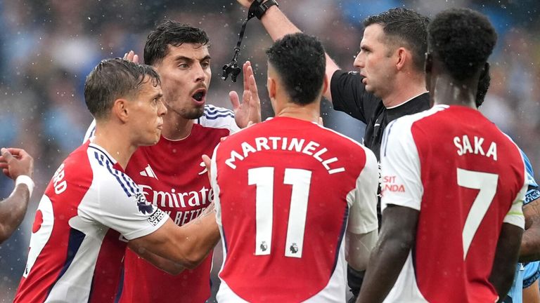 Arsenal players protest as Leandro Trossard is sent off by referee Michael Oliver