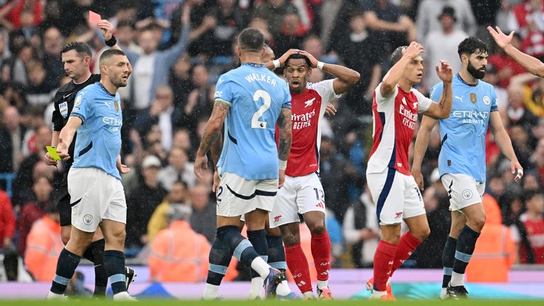 Leandro Trossard and his Arsenal team-mates reacts after he is sent off by referee Michael Oliver