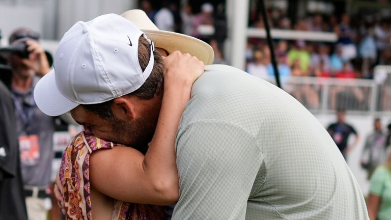 Scottie Scheffler holds his wife Meredith Scudder on the 18th green after winning the final round of the Tour Championship golf tournament, Sunday, Sept. 1, 2024, in Atlanta. (AP Photo/Mike Stewart) 