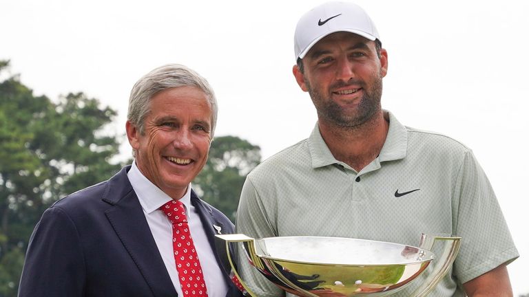 PGA TOUR Commissioner Jay Monahan poses with Scottie Scheffler with the FedExCup Trophy after Scheffler won the final round of the Tour Championship golf tournament, Sunday, Sept. 1, 2024, in Atlanta. (AP Photo/Jason Allen)