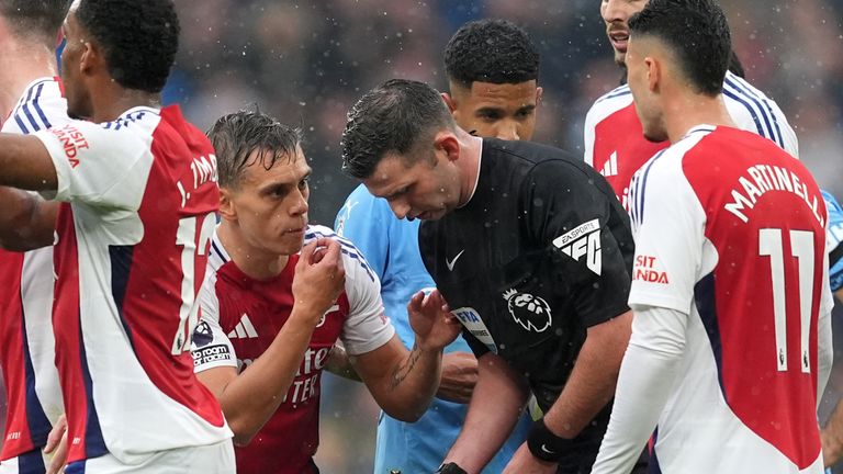 Leandro Trossard speaks to referee Michael Oliver after being sent off at Man City