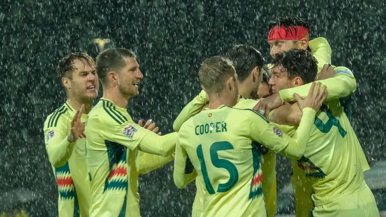 Wales' Kieffer Moore celebrates with teammates in horrendous conditions in Montenegro