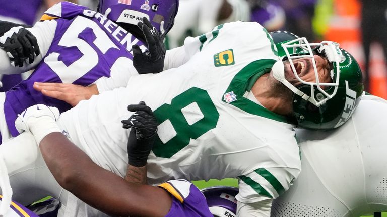 New York Jets quarterback Aaron Rodgers (8), right, reacts as he is tackled during the second half of an NFL football game against the Minnesota Vikings, Sunday, Oct. 6, 2024, at the Tottenham Hotspur stadium in London. (AP Photo/Kirsty Wigglesworth)