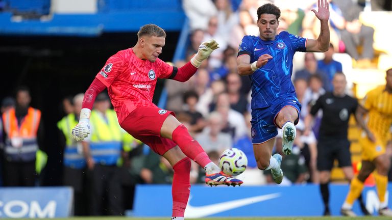 Chelsea's Pedro Neto, right, and Brighton's goalkeeper Bart Verbruggen vie for the ball during a British Premier League soccer match between Chelsea and Brighton at Stamford Bridge, London, Saturday, Sept. 28, 2024. (AP Photo/Kin Cheung)