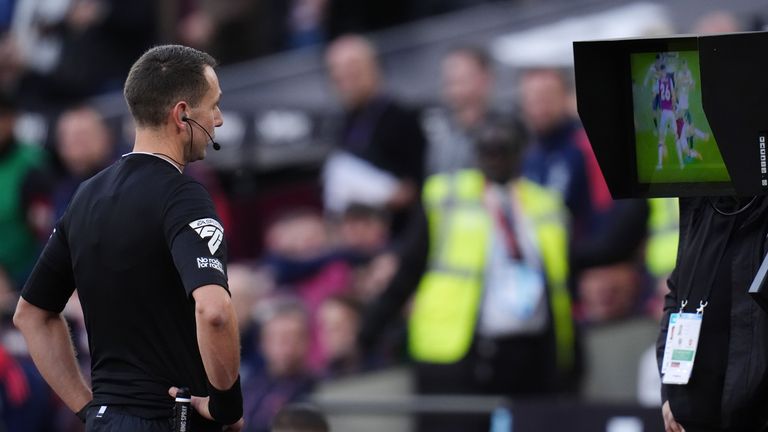 Referee David Coote goes to the VAR monitor to check if there is a possible penalty for West Ham