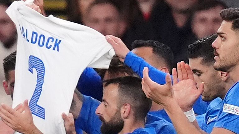 Greece players hold aloft a shirt in memory of George Baldock after Evangelos Pavlidis scores the opening goal of the game during the UEFA Nations League Group B2 match at Wembley Stadium, London. Picture date: Thursday October 10, 2024.