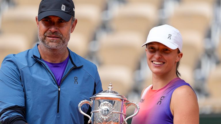 FILE - Poland's Iga Swiatek and her coach Tomasz Wiktorowski hold the trophy after Swiatek won the women's final of the French Open tennis tournament against Italy's Jasmine Paolini at the Roland Garros stadium in Paris, France, Saturday, June 8, 2024. (AP Photo/Thibault Camus, File)