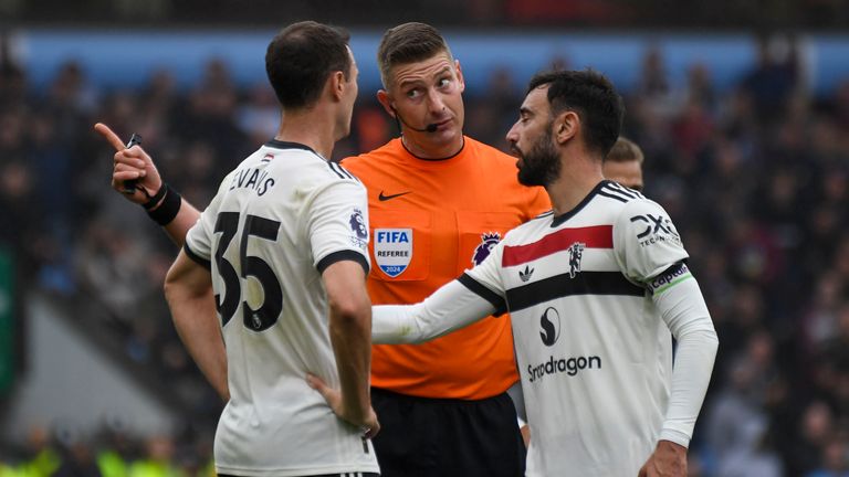 Jonny Evans speaks to referee Rob Jones with Bruno Fernandes