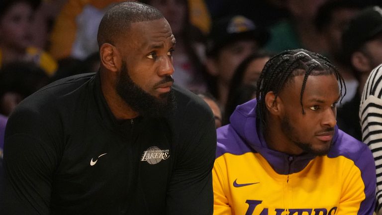 Los Angeles Lakers forward LeBron James, guard Bronny James, watches the play during the first half of an NBA basketball game against the Minnesota Timberwolves on Tuesday, Oct. 22, 2024, in Los Angeles. (AP Photo/Eric Thayer)