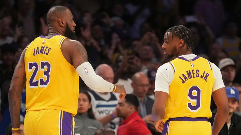 Los Angeles Lakers forward LeBron James (23) and guard Bronny James (9) stand on the court during the first half of an NBA basketball game against the Minnesota Timberwolves, Tuesday, Oct. 22, 2024, in Los Angeles. (AP Photo/Eric Thayer) 