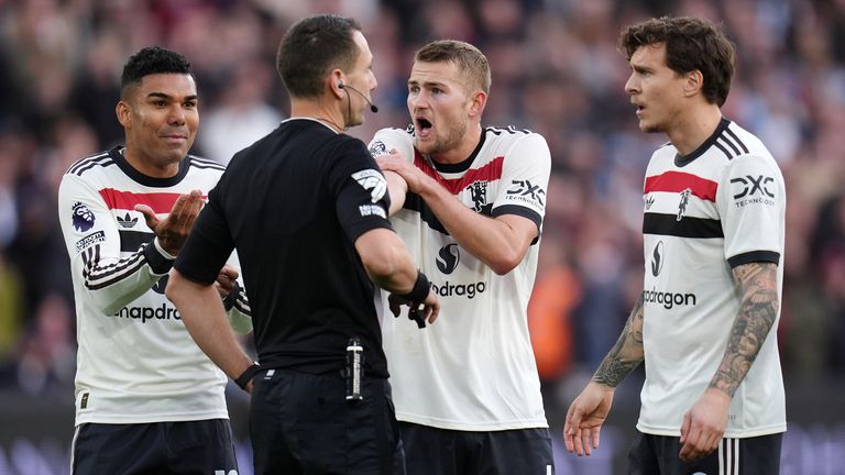 Man Utd players surround referee David Coote