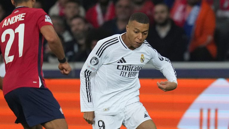 Real Madrid's Kylian Mbappe, right, dribbles the ball past Lille's Benjamin Andre during the Champions League opening phase soccer match between Lille and Real Madrid at the Stade Pierre Mauroy in Villeneuve-d'Ascq, outside Lille, France, Wednesday, Oct. 2, 2024. (AP Photo/Thibault Camus)