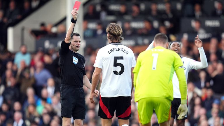 Referee Darren England shows a red card to Fulham's Joachim Andersen