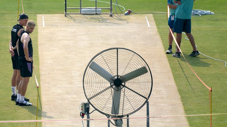 El inglés Brydon Carse, izquierda, Olly Stone, segundo a la izquierda, y el entrenador de Pakistán, Jason Gillespie, derecha, examinan el campo preparándose para el próximo tercer partido de prueba entre Pakistán e Inglaterra, en Rawalpindi, Pakistán, el martes 22 de octubre de 2024. (Foto AP /Anjum Naveed)