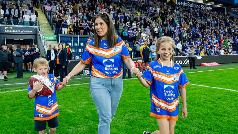 Picture by Allan McKenzie/SWpix.com - 21/06/2024 - Rugby League - Betfred Super League Round 15 - Leeds Rhinos v Leigh Leopards - AMT Headingley, Leeds, England - Lindsey Burrow comes out to the field with her and Rob's son Jackson & daughter Maya.