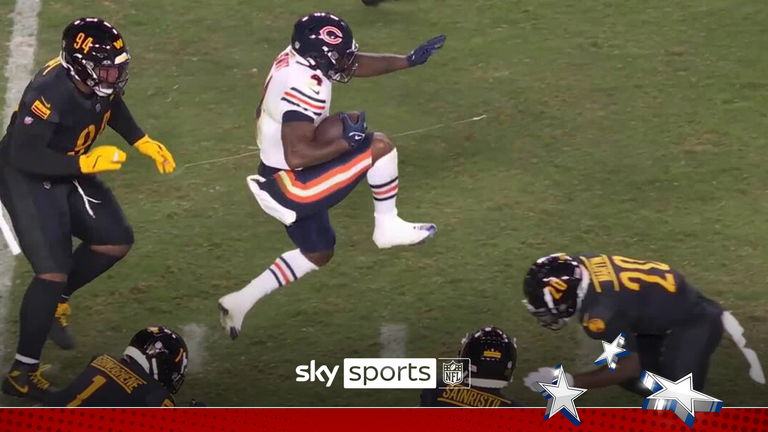 Chicago Bears running back D'Andre Swift leaps over the Washington Commanders defender on a 22-yard gain.