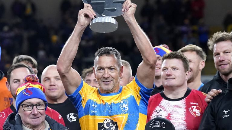 Rob Burrow's League Legends' Danny McGuire (centre) lifts the '745 Game' trophy, with the father of Rob Burrow