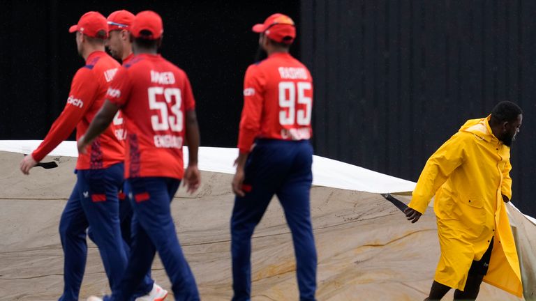 England's players walk off the field as rain delays fifth and final T20 against West Indies in St Lucia (Associated Press)