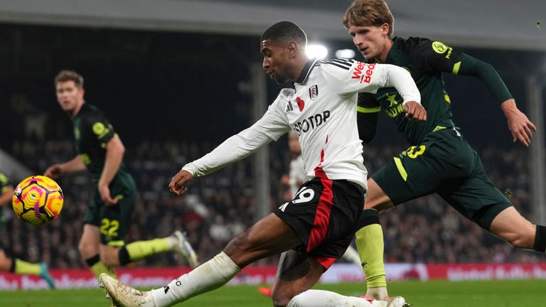 Fulham's Reiss Nelson, left, takes a shot at goal as Brentford's Mads Roerslev defends