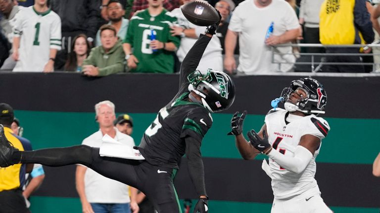 New York Jets wide receiver Garrett Wilson (5) catches a pass for a touchdown as Houston Texans cornerback Kamari Lassiter (4) defends during the second half of an NFL football game Thursday, Oct. 31, 2024, in East Rutherford, N.J. (AP Photo/Frank Franklin II)