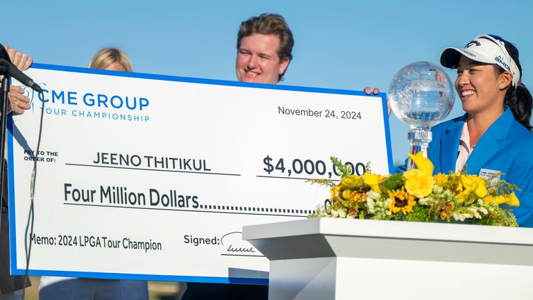 Jeeno Thitikul, right, smiles on the 18th green after getting a $4m check for winning the LPGA CME Group Tour Championship golf tournament Sunday, Nov. 24, 2024, in Naples, Fla. (AP Photo/Chris Tilley)