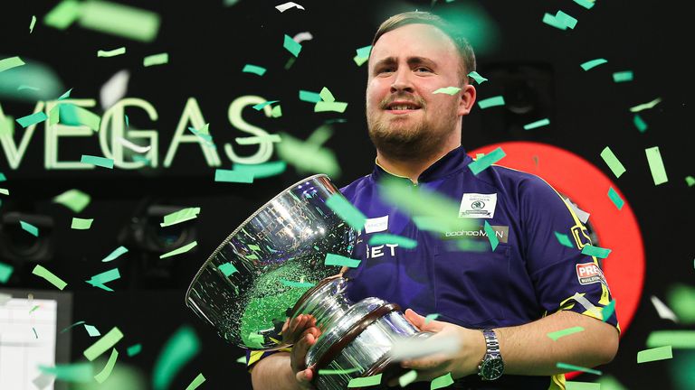 Luke Littler celebrates with the Eric Bristow Trophy after winning the Grand Slam of Darts (pic: PDC)