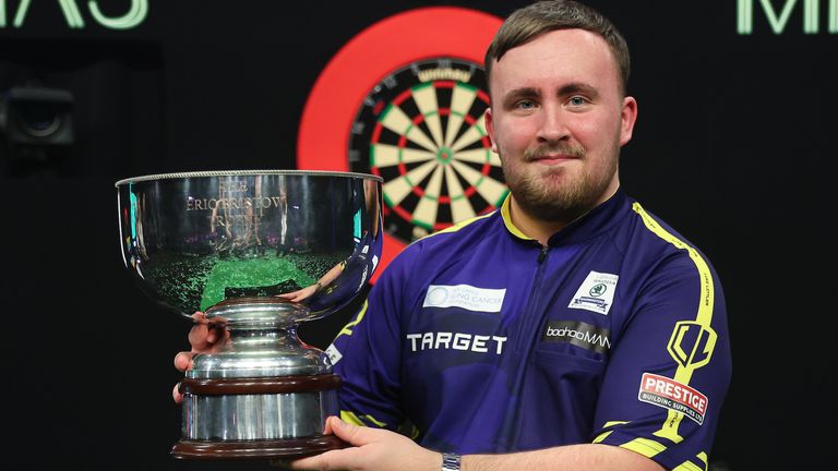 Luke Littler celebrates with the Eric Bristow Trophy after winning the Grand Slam of Darts (pic: PDC)